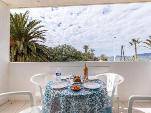 une table avec un chiffon de table bleu et blanc sur un balcon dans l'établissement Apartment Super Plage-6 by Interhome, à Saint-Cyr-sur-Mer