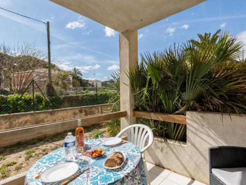 une table avec des assiettes de nourriture sur un balcon dans l'établissement Apartment Super Plage-3 by Interhome, à Saint-Cyr-sur-Mer