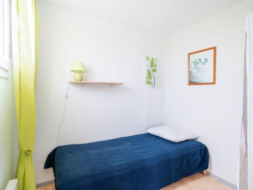 Cette chambre comprend un lit avec une couverture bleue. dans l'établissement Apartment Bleu Marine-8 by Interhome, à Lacanau-Océan