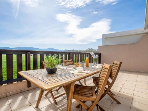 une table et des chaises en bois sur un balcon dans l'établissement Apartment Les Embruns-16 by Interhome, à Saint-Cyprien