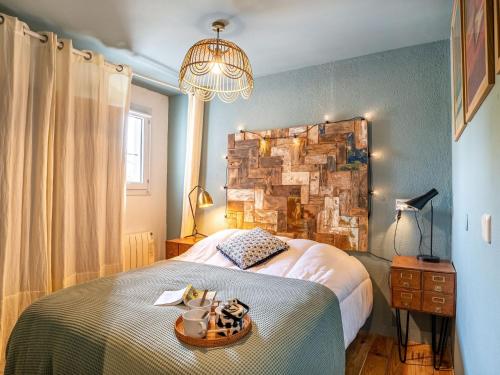 une chambre avec un grand lit et un lustre dans l'établissement Apartment Zirlinga-9 by Interhome, à Bidart