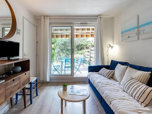un salon avec un canapé bleu et une table dans l'établissement Apartment Bleu Marine-9 by Interhome, à Lacanau-Océan