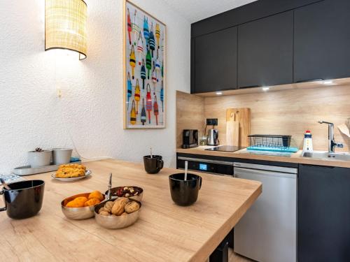 une cuisine avec des bols de nourriture sur une table en bois dans l'établissement Apartment Bleu Marine-9 by Interhome, à Lacanau-Océan