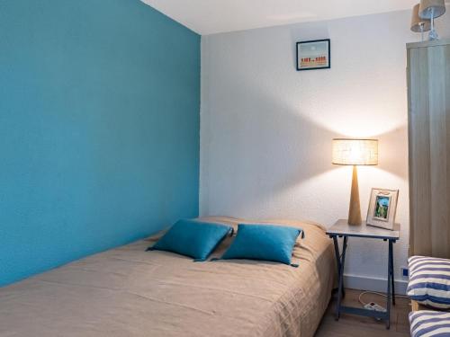 une chambre avec un lit avec deux oreillers bleus dans l'établissement Apartment Bleu Marine-9 by Interhome, à Lacanau-Océan
