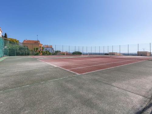 un court de tennis vide avec une clôture en arrière-plan dans l'établissement Apartment Le Grand Large-1 by Interhome, à Hyères