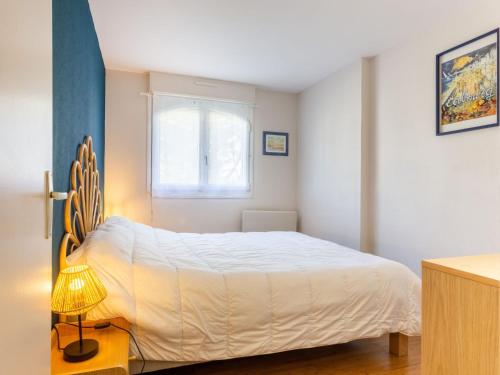 une chambre avec un lit blanc et une fenêtre dans l'établissement Apartment Montaigu by Interhome, à Cabourg