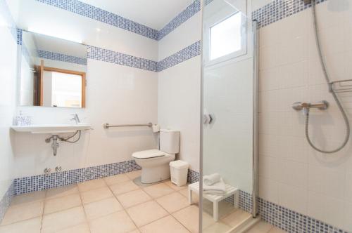 Un baño con ducha, inodoro y lavabo. en Villa Violeta by Sonne Villas, en Cala Galdana