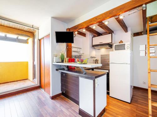 Il comprend une cuisine équipée d'un réfrigérateur blanc et une télévision. dans l'établissement Studio Les Balcons de la Méditerranée-36 by Interhome, à Narbonne-Plage