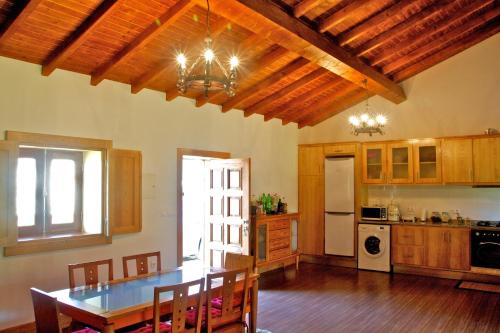 a kitchen with a dining room table and a kitchen with at Casa de Reborido in Ponte da Barca