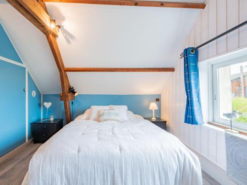 a bedroom with a white bed with blue walls and a window at Holiday Home Le havre de paix by Interhome in Créances