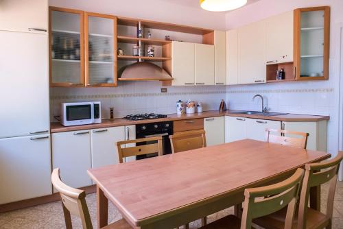 a kitchen with a wooden table and a kitchen with a refrigerator at A11 - Varano, delizioso trilocale con giardino in Ancona