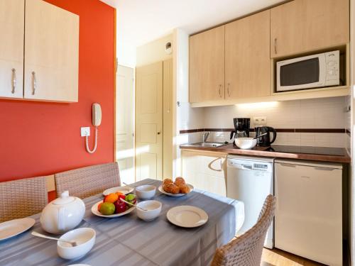 une cuisine avec une table avec des bols de fruits dessus dans l'établissement Studio Le Village - B1 418 by Interhome, à Agay