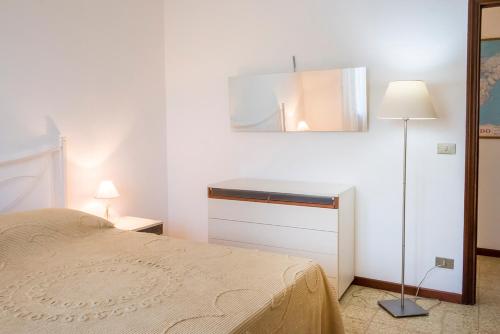 a bedroom with a bed and a mirror and a lamp at A11 - Varano, delizioso trilocale con giardino in Ancona