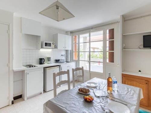 - une cuisine blanche avec une table et une assiette de nourriture dans l'établissement Apartment Super Plage-8 by Interhome, à Saint-Cyr-sur-Mer