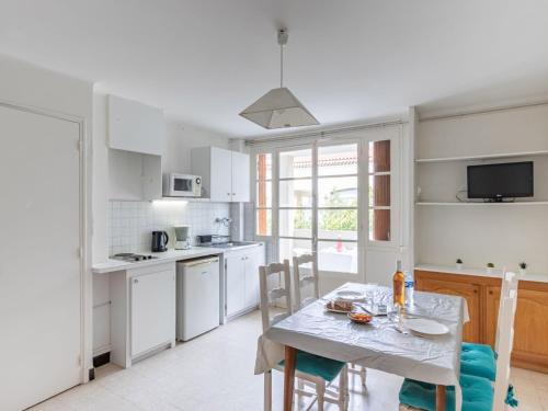 une cuisine avec une table et des chaises et une cuisine avec des armoires blanches dans l'établissement Apartment Super Plage-8 by Interhome, à Saint-Cyr-sur-Mer