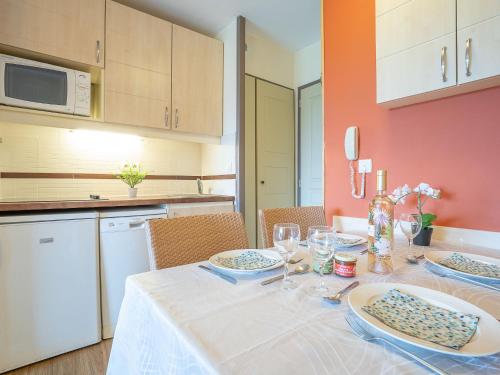 une cuisine avec une table avec des assiettes et des verres dessus dans l'établissement Studio Le Village - C3 217 by Interhome, à Agay