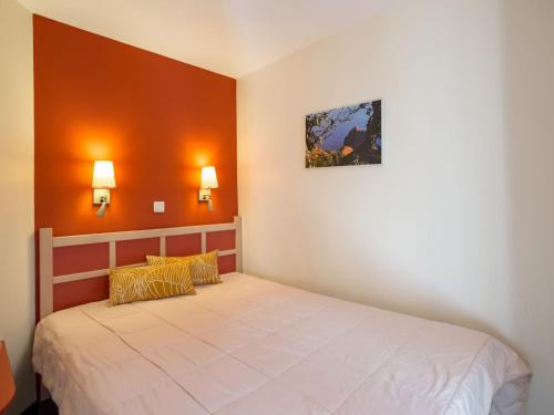 - une chambre avec un lit aux murs orange dans l'établissement Apartment Le Belvédère - R9 137 by Interhome, à Agay