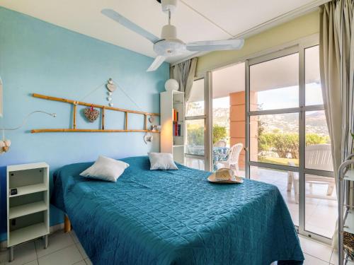 - une chambre bleue avec un lit et une grande fenêtre dans l'établissement Apartment Le Belvédère - V2 009 by Interhome, à Agay