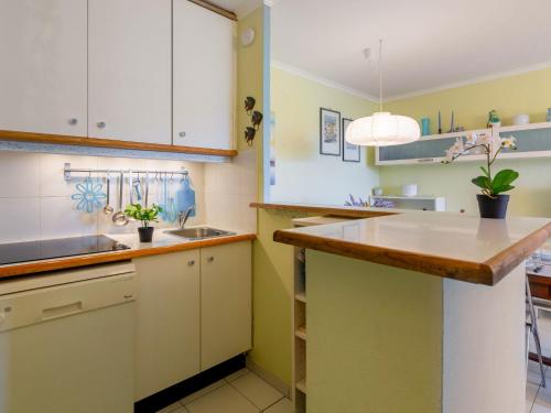 une cuisine avec des armoires blanches et un comptoir en bois dans l'établissement Apartment Le Belvédère - V2 009 by Interhome, à Agay