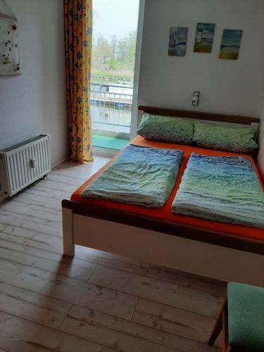 two beds in a room with a window at FEWO "Hafenblick" in Ueckermünde