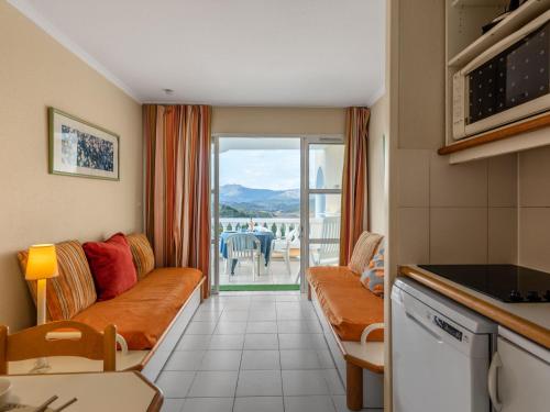 d'un salon avec un canapé et une vue sur un balcon. dans l'établissement Studio Le Village - C5 232 by Interhome, à Agay