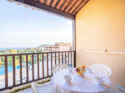 d'une table blanche avec des chaises et d'un balcon avec vue. dans l'établissement Apartment Le Village - E1320 by Interhome, à Agay