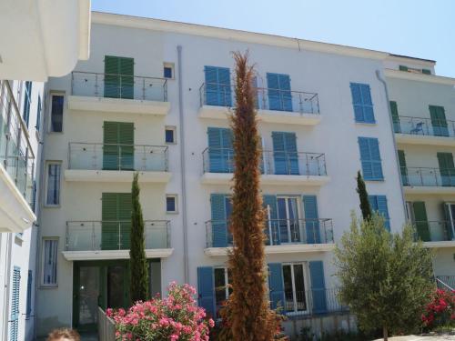 un grand bâtiment blanc avec volets verts dans l'établissement Apartment Villa Tyrrenia-1 by Interhome, à Rogliano