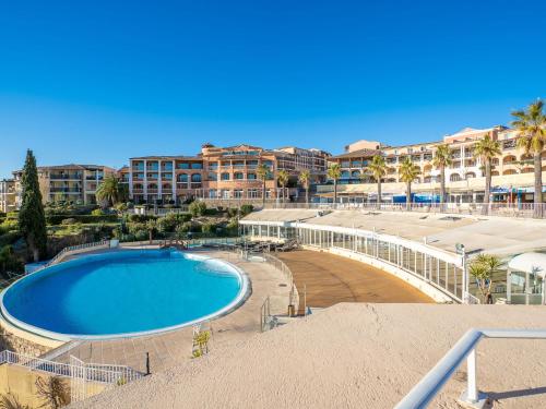 une grande piscine devant un complexe hôtelier dans l'établissement Apartment Les Bastides - I4143 by Interhome, à Agay