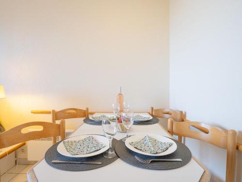 - une table à manger avec des assiettes et des verres à vin dans l'établissement Apartment Le Village - E1320 by Interhome, à Agay