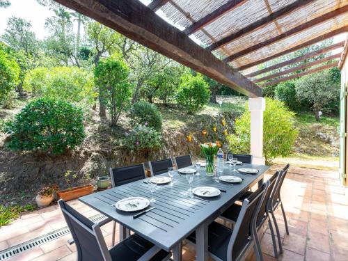 Une table à manger et des chaises sont disponibles sur la terrasse. dans l'établissement Holiday Home Villa Les 4 B by Interhome, à Sainte-Maxime