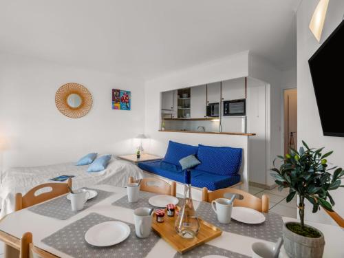 un salon avec une table et un canapé bleu dans l'établissement Apartment Les Bastides - I4143 by Interhome, à Agay