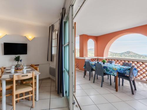 une salle à manger avec une table et des chaises et un balcon dans l'établissement Apartment Les Bastides - I4143 by Interhome, à Agay