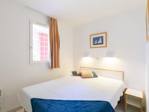 un lit blanc dans une chambre avec une fenêtre dans l'établissement Apartment Le Hameau - K3 122 by Interhome, à Agay