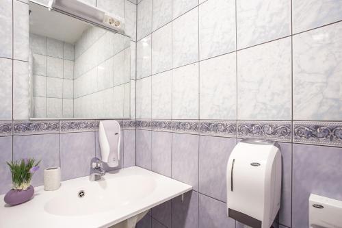a white bathroom with a sink and a mirror at Pärnu Villa Harmony in Pärnu