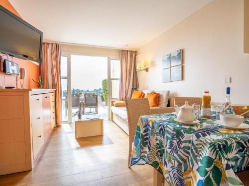 Il comprend une cuisine et un salon avec une table et une télévision. dans l'établissement Apartment Le Village - C4 008 by Interhome, à Agay