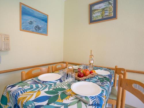 - une table avec des assiettes et une corbeille de fruits dans l'établissement Studio L'Esquinade - J3 402 by Interhome, à Agay