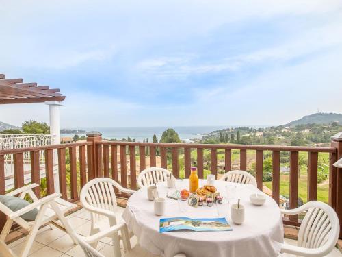 een tafel en stoelen op een balkon met uitzicht op de oceaan bij Apartment Village Cap Estérel - Le Village-64 by Interhome in Agay - Saint Raphael