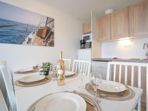 une cuisine avec une table avec des assiettes et des verres à vin dans l'établissement Apartment Le Village - C4324 by Interhome, à Agay