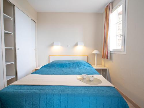 - une chambre dotée d'un lit bleu avec deux tasses dans l'établissement Apartment Le Village - C4324 by Interhome, à Agay