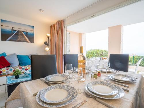 une salle à manger avec une table avec des assiettes et des verres à vin dans l'établissement Apartment Les Bastides - I2 047 by Interhome, à Agay