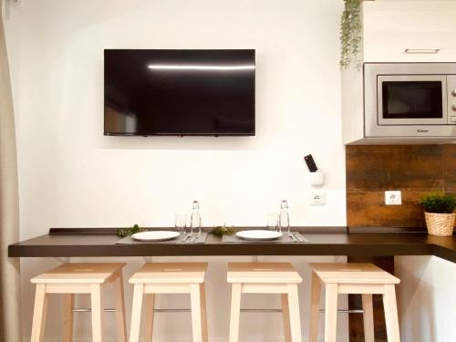 - une cuisine avec un bar avec des tabourets et une télévision murale dans l'établissement Studio L'Esquinade - J2 206 by Interhome, à Agay