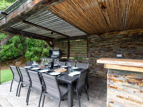 un patio avec une table et des chaises sous un toit en bois dans l'établissement Villa Villa Trinita-1 by Interhome, à Porto-Vecchio
