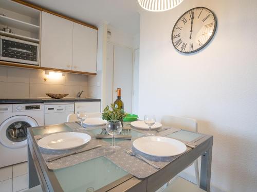 une cuisine avec une table et une horloge au mur dans l'établissement Studio Le Village - C9 279 by Interhome, à Agay