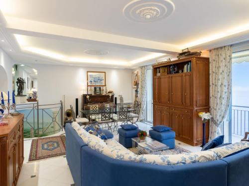 uma sala de estar com um sofá azul e uma varanda em Apartment Grimaldi by Interhome em Mortola Superiore