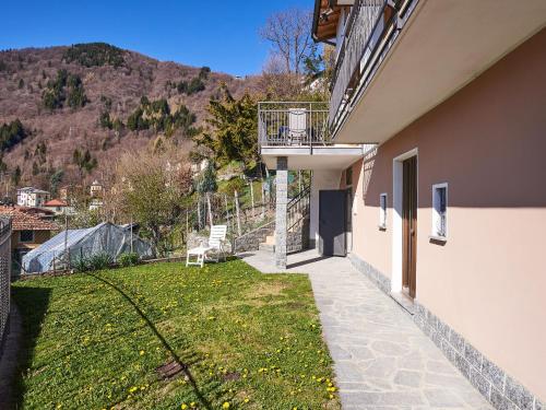 a house with a balcony and a grass yard at Holiday Home Casa del Sole by Interhome in Casasco Intelvi
