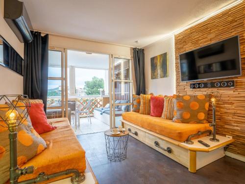 un salon avec un canapé et une télévision dans l'établissement Apartment L'Esquinade - J4236 by Interhome, à Agay