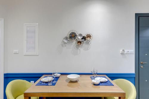 a dining room table with chairs and a chandelier at Polis Suite in Ermoupoli