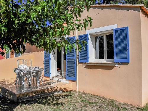 une terrasse avec une table et des volets bleus sur une maison dans l'établissement Holiday Home Cala Bianca-3 by Interhome, à Borgo