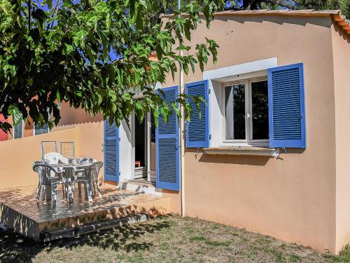 a patio with a table and blue shutters on a house at Holiday Home T3 Cabine by Interhome in Borgo