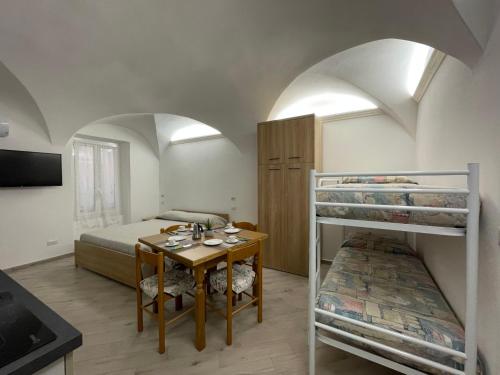 a bedroom with a bed and a table and bunk beds at Apartment Tra Sole e Mare by Interhome in Spotorno